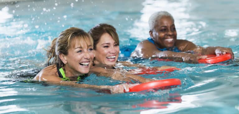 Multiracial middle-aged women swimming in pool